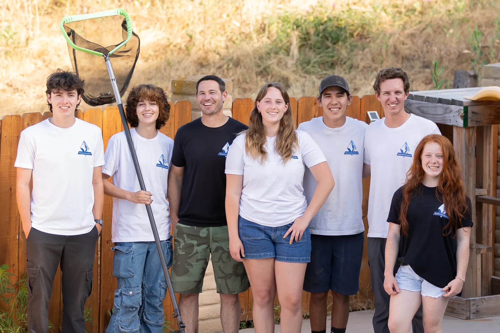 Murdock Pool Service team standing together with pool cleaning equipment