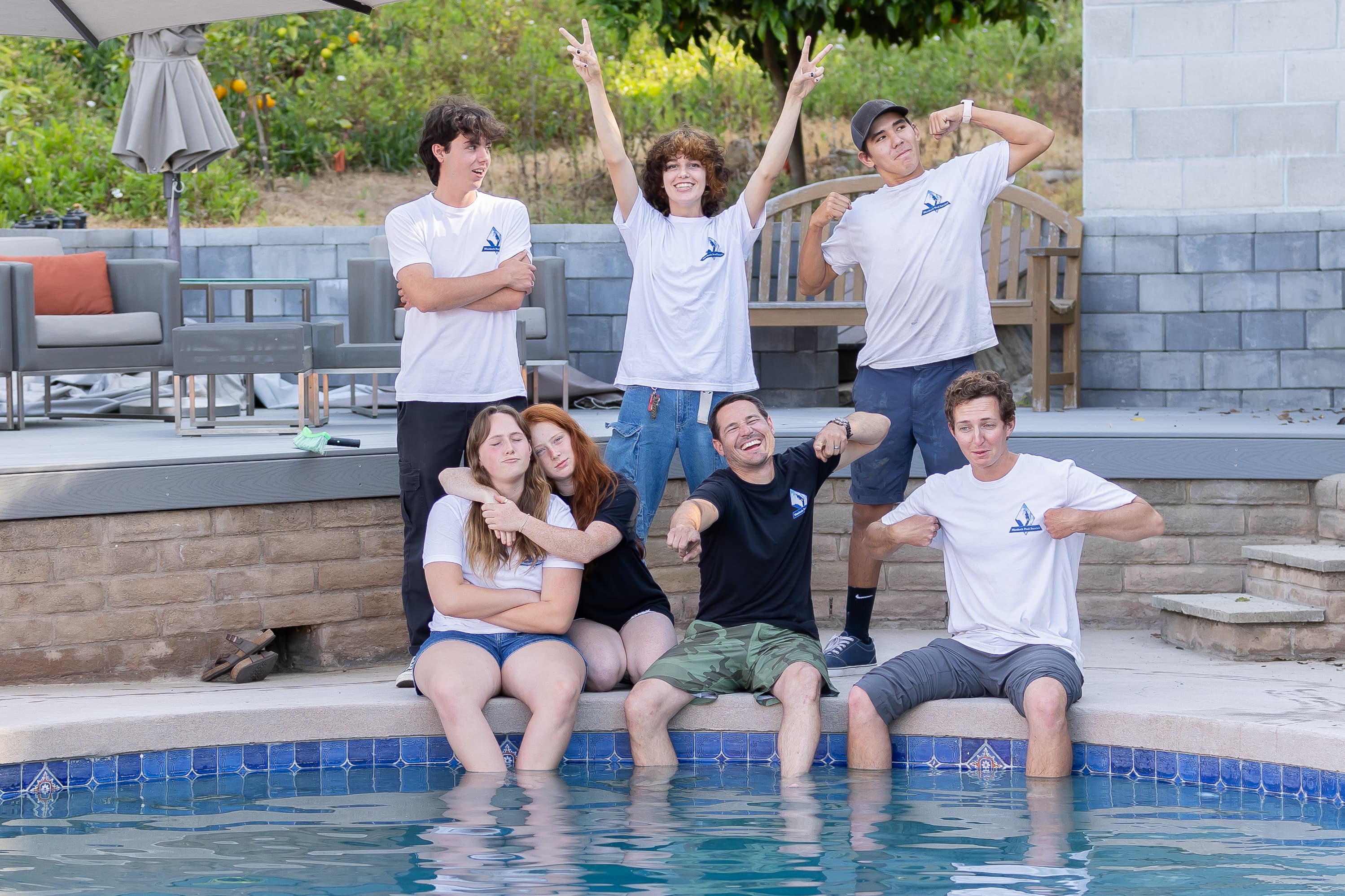 The Murdock Pool Service team having fun and striking silly poses by the pool