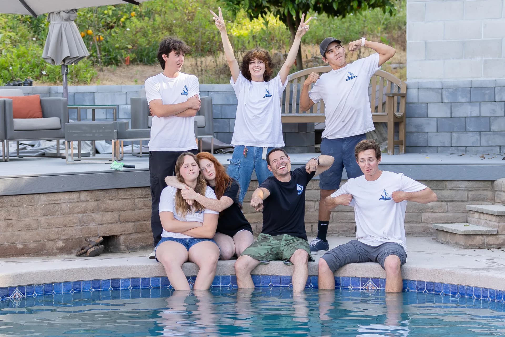 The Murdock Pool Service team having fun and striking silly poses by the pool