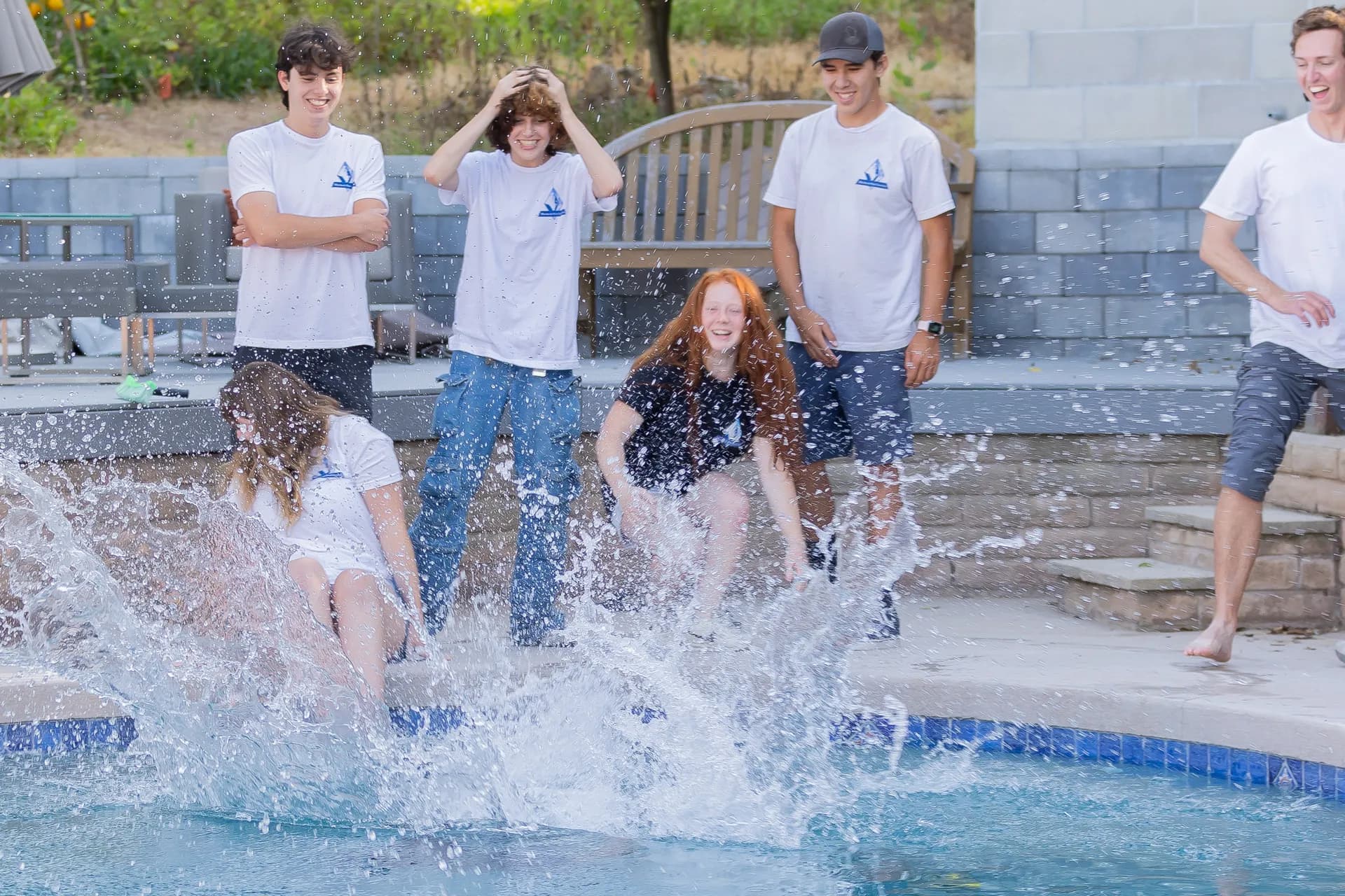 Murdock Pool Service team laughing and splashing into the pool