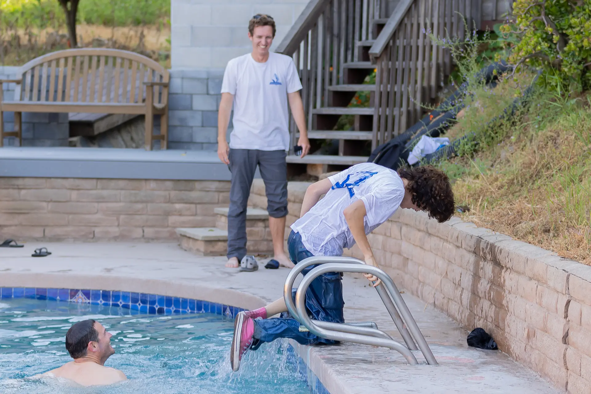 Brett laughing as a team member dives into a customer pool