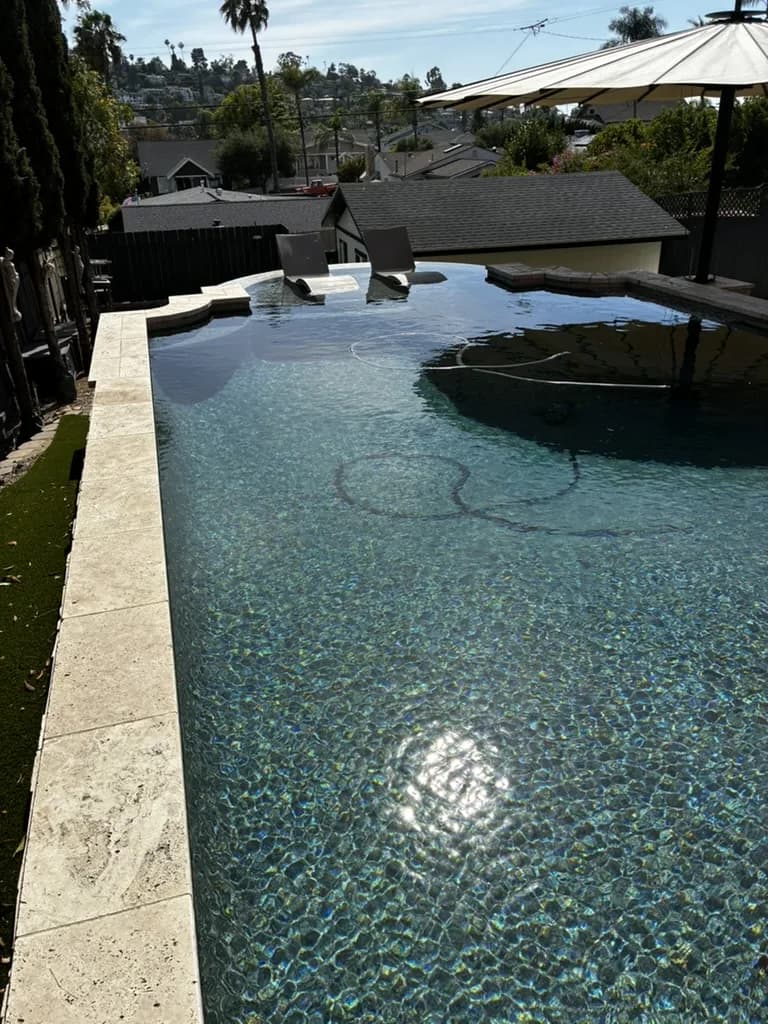 Portrait view of a customer infinity pool overlooking the San Diego skyline, maintained by Murdock Pool Service