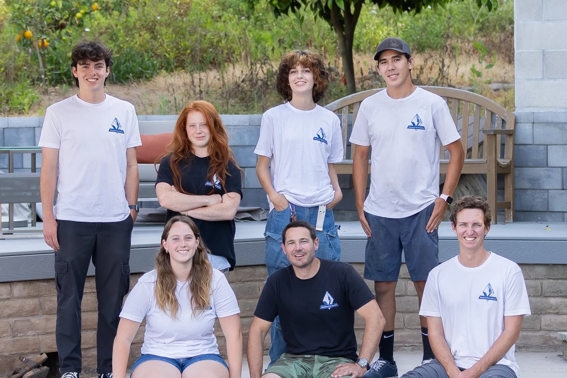 Murdock Pool Service team group photo by the pool patio