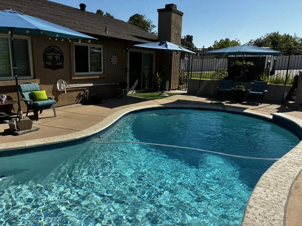 Stone-veneer customer pool on a shaded La Mesa patio after weekly Murdock Pool Service maintenance